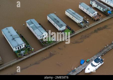 Kempsey, Worcestershire, 12. Januar 2023 - Ferienwagen auf dem Seeufer-Campingplatz in Kempsey, Worcestershire, wurden von Hochwasser überschwemmt, nachdem der Fluss Severn Severn seine Ufer geplatzt hatte. Die erhöhten statischen Caravans haben jetzt einen Blick auf ein großes Gewässer und unzugängliche, vertäute Sportboote. Die Höhe des Flusses wird voraussichtlich am Samstag erreicht. Quelle: Stop Press Media/Alamy Live News Stockfoto