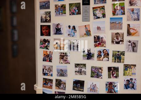 Ternopil, Ukraine - 11. Januar 2023: Kühlschranktür gefüllt mit vielen Erinnerungsfotos der Familie. Stockfoto