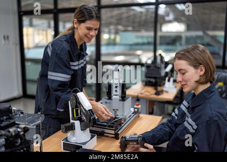 Ingenieurin sitzt im Roboterfabrikationsraum und prüft die Qualität der elektronischen Steuerplatine Stockfoto