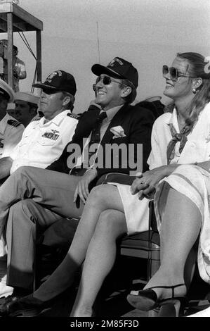 John F. Lehman, Marinesekretär der Marine, und seine Frau Barbara, genießen die Aufführung des Bob Hope Special an Bord des Flugzeugträgers USS LEXINGTON (AVT-16) anlässlich des 75. Jahrestages der Marinestation. Basis: Marine Air Station, Pensacola Bundesstaat: Florida (FL) Land: Vereinigte Staaten von Amerika (USA) Stockfoto