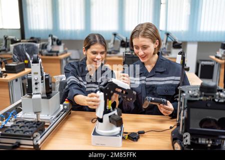 Ingenieurin sitzt im Roboterfabrikationsraum und prüft die Qualität der elektronischen Steuerplatine Stockfoto