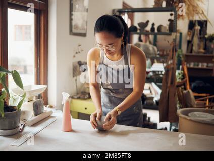 Gestalten, Formen und Töpfern Sie Geschäftsfrau mit Ton für Kreativität, Inspiration und Kunstverarbeitung in der Werkstatt. Kreativ, kleines Unternehmen und asiatisches Mädchen Stockfoto