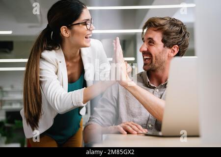 Glückliche Gruppe multiethnischer Geschäftsleute, die Erfolge im Unternehmen feiern Stockfoto