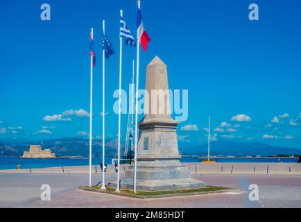 Ein Blick auf das Denkmal für die Morea Expedition auf dem Philellinon-Platz, in Napflio, Griechenland, und Burg Bourtzi im Meer im Hintergrund Stockfoto