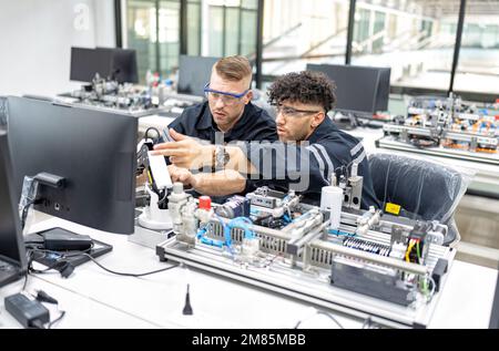 Ingenieur sitzt im Roboterfabrikationsraum und prüft die Qualität der elektronischen Schalttafeln Stockfoto