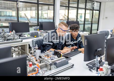 Ingenieur sitzt im Roboterfabrikationsraum und prüft die Qualität der elektronischen Schalttafeln Stockfoto