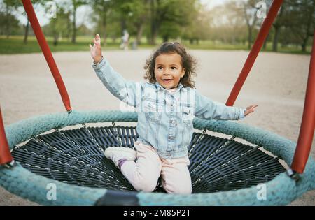 Spielen auf dem Spielplatz, Mädchen im Park mit Outdoor-Spaß, frühkindliche Entwicklung mit Kleinkind auf Trampolin. Kind, Freiheit und Energie, verspielt und Stockfoto