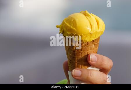 Eine gekürzte Hand mit Eiskrem-Konus Stockfoto