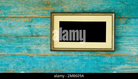 Leerer wertvoller, handgefertigter alter Rahmen mit leerem Passepartout an rustikaler Holzwand, kostenloser Kopierbereich, Modell Stockfoto
