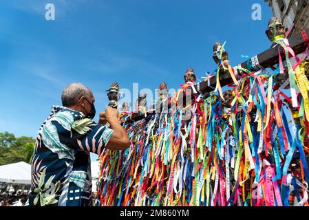 Salvador, Bahia, Brasilien - 06. Januar 2023: Katholischer Mann legt während der Messe ein Band auf das Geländer der Kirche Senhor do Bonfim. Stadt Salvador, Bahia Stockfoto