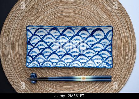 Japanischer oder chinesischer Tisch mit traditioneller Tischdecke und Essgeschirr mit Hintergrund und weißem Hintergrund. Speise- und Restaurantkonzept. Flach verlegt. Stockfoto