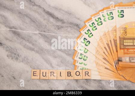 Word EURIBOR ist in Holzbuchstaben geschrieben, nahe eines Teils von 50 Euro-Banknoten. Stockfoto