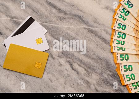 Nahaufnahme von 50 Euro-Banknoten und Bankkarten. Konzept Des Vergleichs Von Bargeld Und Non-Bargeld. Stockfoto
