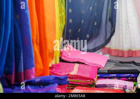 Künstlerische Vielfalt Schattierungen Farben Ornamente Muster, Nahaufnahme von gestapelten Saris oder Sarees im Display des Einzelhandels. Stockfoto