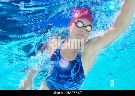Schwimmen zu einer persönlichen Bestform. Unterwasseraufnahme einer Schwimmerin. Stockfoto
