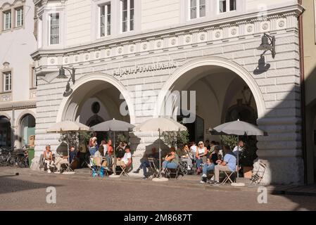 Bolzano Cafés, Blick auf die Menschen, die sich an Cafetstischen in der Via della Mostra (Mustergasse) in der historischen Altstadt von Bozen, Italien, entspannen Stockfoto
