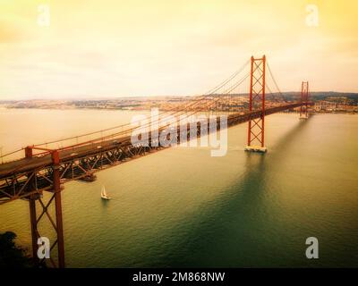 Die Brücke 25 de Abril ist eine Hängebrücke in Portugal über den Tagus, die die Stadt Lissabon, Hauptstadt von Portugal, mit der Stadt Almada verbindet. Stockfoto