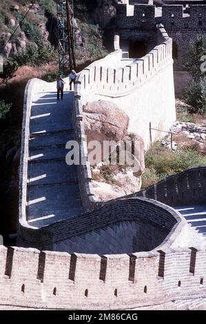 Ein Blick auf einen Teil der Chinesischen Mauer, der sich nordwestlich und nördlich von Peking befindet und den Fußweg zu einem befestigten Turm zeigt. Der Bau der Mauer begann im 7. Jahrhundert v. Chr. durch den ersten Kaiser Quin Shui Hunag Di. Sie ist 25 Meter hoch und an einigen Stellen fast 25 Meter dick. Die ursprüngliche Mauer, 1500 Kilometer lang, dauerte zehn Jahre, um sie fertigzustellen. Im Jahr 1368 n. Chr. setzte die Ming-Dynastie den Bau 200 Jahre lang fort und ist jetzt über 3750 Meilen lang. Exaktes Datum Aufnahme Unbekannt. Land: China (CHN) Stockfoto