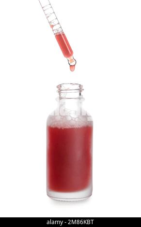 Tropfen von Serum aus der Pipette in die Flasche auf weißem Hintergrund Stockfoto