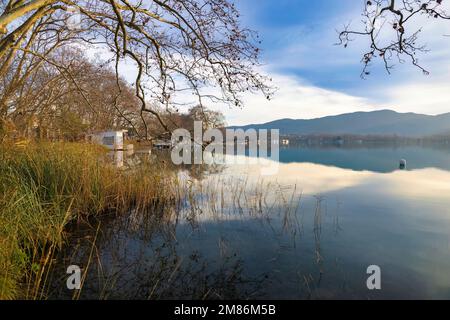 Blick auf Lake Banyoles bei Sonnenuntergang mit einer Reihe von Angelhütten am Seeufer. Katalonien, Spanien Stockfoto