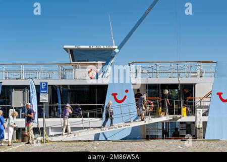 Dordrecht, Niederlande - August 2022: Menschen, die nach einem Besuch der Stadt zu ihrem Kreuzfahrtschiff zurückkehren. Das Schiff wird von TUI River Cruises betrieben Stockfoto