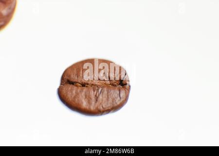 Mehrere Kaffeebohnen vor weißem Hintergrund fotografiert. Hochwertiges Foto Stockfoto