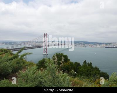 Die Brücke 25 de Abril ist eine Hängebrücke in Portugal über den Tagus, die die Stadt Lissabon, Hauptstadt von Portugal, mit der Stadt Almada verbindet. Stockfoto