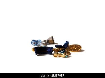 Goldene Geschenke mit bösen Augenperlen. Viel Glück. Schmuckkonzept mit hervorgehobenem Amulett. Schmuckgegenstände auf weißem Hintergrund isoliert. Stockfoto