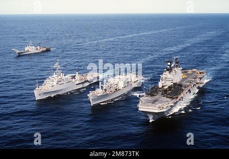 Aus der Luft sehen Sie das amphibische Sturmschiff USS SAIPAN (LHA-2), das Kampfhandwerksschiff USS CONCORD (AFS-4), die Amphibien-Transportanlage USS NASHVILLE (LPD-13) und ein Panzerlandeschiff. Land: Unbekannt Stockfoto