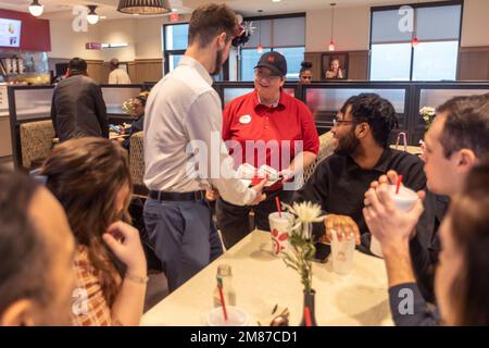 Livonia, Michigan – Ein Mitarbeiter von Chick-fil-A liefert am Tag der großen Eröffnung des Restaurants eine Bestellung an einen Tisch. Stockfoto