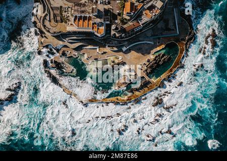 Blick aus der Vogelperspektive auf Porto Moniz mit vulkanischen Lava-Swimmingpools, Madeira. Salzwasserpools, die in Lavaformationen des Atlantischen Ozeans entstanden sind. Herrlich Stockfoto