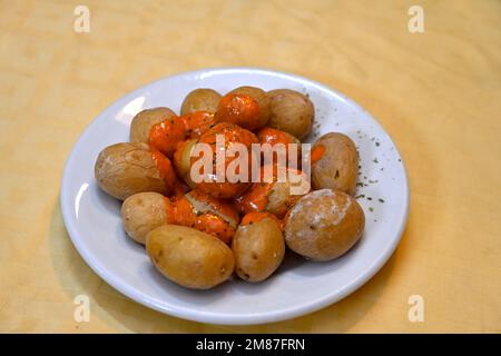 Gericht aus Papas arrugadas – Kanarische Salzkartoffeln (zerknitterte Kartoffeln) mit roter Mojo-Sauce Stockfoto