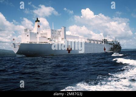 Ein Steuerbord-Viertelblick des Krankenhausschiffs USNS MERCY (T-AH-19) mit dem Flottenschlepper USNS SIOUX (T-ATF-171) daneben. Basis: Legaspi Land: Philippinen (PHL) Stockfoto