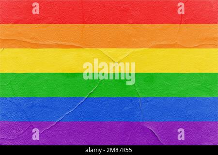 Rainbow-Flagge mit Rissen an der strukturierten Wand. Hintergrund für Grunge im Freien Stockfoto