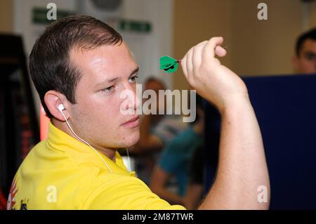 Profi-Dartspieler arron Monk wirft Dart uk Stockfoto