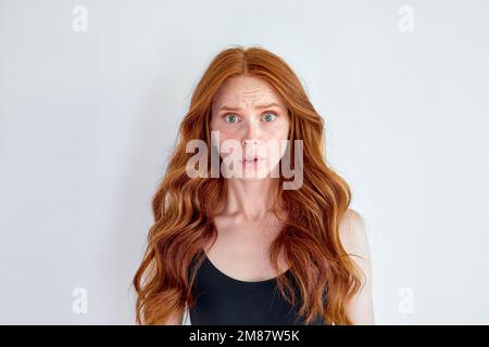 Porträt einer hübschen, überraschten Frau mit offenem Mund und offenen Augen, die auf die Kamera schaut, isoliert auf weißem Studiohintergrund, Kopierraum für Werbung. HU Stockfoto