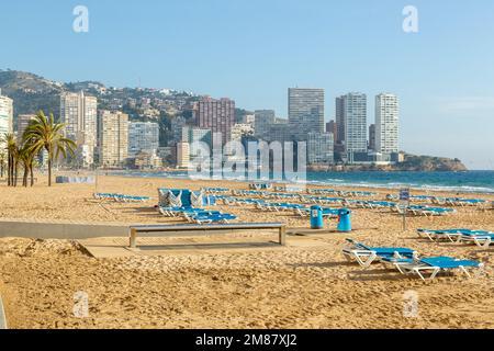 Sonnenliegen am Strand von Benidorm im Dezember Stockfoto