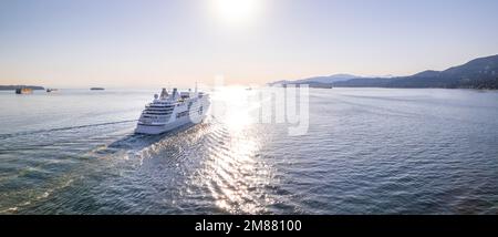 Kreuzfahrtschiff, das bei Sonnenuntergang aus dem Hafen von Vancouver aussegelt, Kreuzfahrtlinie, großes Boot, Luxuskreuzfahrt, Luftaufnahmen. Stockfoto