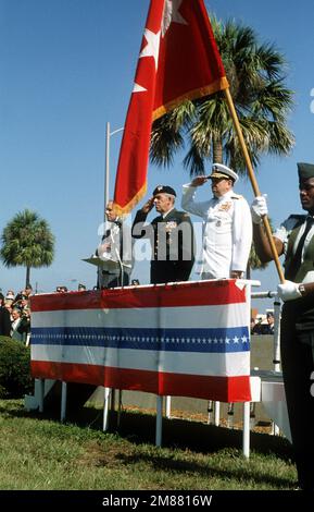 William H. Taft IV., stellvertretender Verteidigungsminister, ganz links; GEN. James T. Lindsay, Oberbefehlshaber, USA Special Operations Command, Center, und ADM. William J. Crowe Jr., Chairman, Joint Chiefs of STAFF, ehren die Flagge während der USA Aktivierungszeremonie des Sondereinsatzkommandos (USSOCOM). Basis: Luftwaffenstützpunkt MacDill Bundesstaat: Florida (FL) Land: Vereinigte Staaten von Amerika (USA) Stockfoto