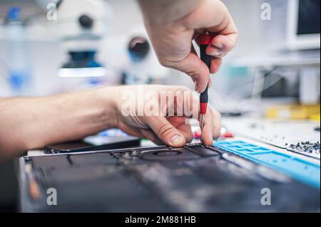 Technischer Support und Behebung von Problemen mit Gadgets. Wartung, Reparatur, Reinigung, Wartung von Computern. Reparaturwerkstatt. Hardwarewartung. Männliche Technici Stockfoto
