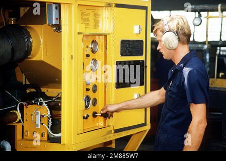 Aviation Support Equipment Technician E (Electrical) 2. Klasse R. Smith testet eine mobile Klimaanlage außerhalb einer Werkstatt der Intermediate Maintenance Department (AIMD) eines Flugzeugs. Basis: Marineflugstation, Jacksonville Bundesstaat: Florida (FL) Land: Vereinigte Staaten von Amerika (USA) Stockfoto