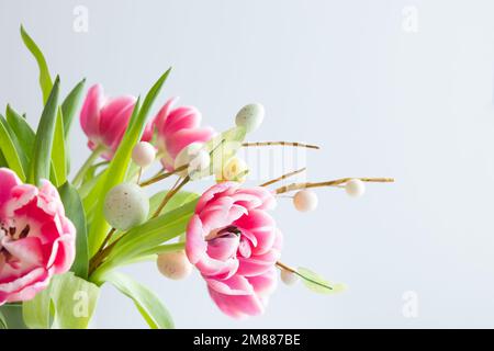 Frischer Strauß rosafarbener Tulpen mit einem Zweig ostereier auf weißem Hintergrund mit Kopierbereich Stockfoto
