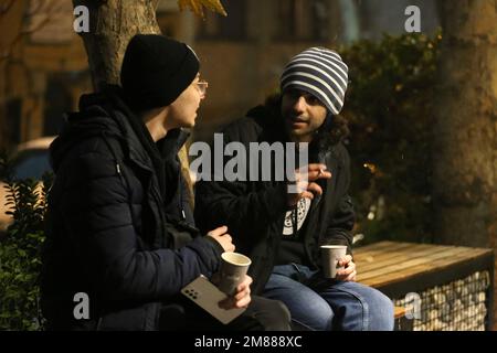 Teheran, Teheran, Iran. 11. Januar 2023. ALIN JOHARCHI (L), iranischer Musiker, Sänger und Songwriter, spricht am 11. Januar 2023 vor einem Café im Norden Teherans, Iran, mit seinem Freund. Allin Joharchi wurde am 9. September 1998 geboren. Er zeigte zuerst Interesse an Musik, als seine Cousins Gitarre spielten und in jungen Jahren für ihn sangen. Und später entdeckte er seine Leidenschaft für Musik als er Guitar Hero auf seiner Xbox spielte, begann er mit 10 Jahren mit dem Spielen der E-Gitarre und veröffentlichte 2018 sein erstes Album „for Your Own“. Das Album lautete hauptsächlich Indie Folk und Indie Rock und English but Stockfoto