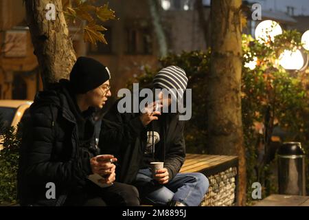 Teheran, Teheran, Iran. 11. Januar 2023. ALIN JOHARCHI (L), iranischer Musiker, Sänger und Songwriter, spricht am 11. Januar 2023 vor einem Café im Norden Teherans, Iran, mit seinem Freund. Allin Joharchi wurde am 9. September 1998 geboren. Er zeigte zuerst Interesse an Musik, als seine Cousins Gitarre spielten und in jungen Jahren für ihn sangen. Und später entdeckte er seine Leidenschaft für Musik als er Guitar Hero auf seiner Xbox spielte, begann er mit 10 Jahren mit dem Spielen der E-Gitarre und veröffentlichte 2018 sein erstes Album „for Your Own“. Das Album lautete hauptsächlich Indie Folk und Indie Rock und English but Stockfoto