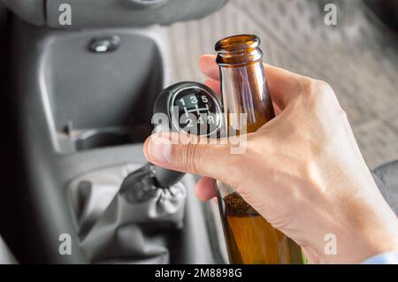 Nahaufnahme von handfahrendem Auto und Alkoholkonsum gefährlich Stockfoto