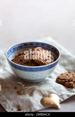 Hausgemachte Kekse mit Müsli und Samen, Schüssel auf einem Tisch, Seitenansicht Stockfoto