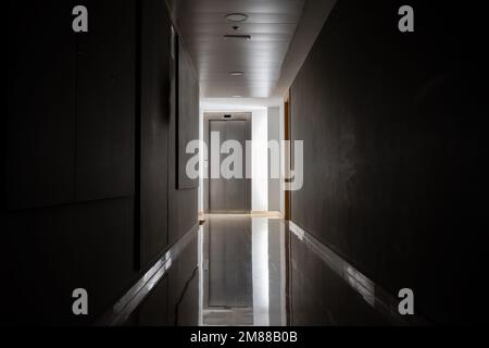 Dunkle und geheimnisvolle Korridor in einem Krankenhaus Gebäude.Türraum Perspektive in einsamen ruhigen Gebäude mit Licht auf schwarz-weiß-Stil. Horrorlandschaft Stockfoto