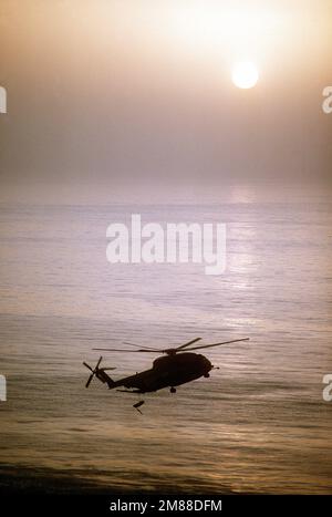 Eine Silhouette eines RH-53D Sea Hallion Helikopters, der eine Mine-Gegenmaßnahmen-Operation durchführt. Land: Unbekannt Stockfoto