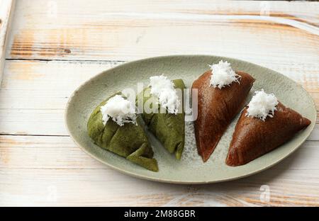 Apem oder Apang Cake, traditioneller indonesischer Dampfkuchen aus Reismehl und Palmenzucker. Belag mit geriebener Kokosnuss Stockfoto