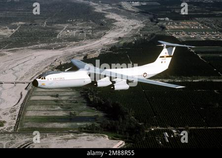 Air-to-Air-Seitenansicht eines C-141B-Starlifters, „Spirit of the Inland Empire“ vom 63. Militärflugflügel, Norton AFB, Kalifornien, fliegt über die Obstplantagen in der Nähe des südkalifornischen Stützpunkts. Exaktes Datum Aufnahme Unbekannt. Land: Unbekannt Stockfoto